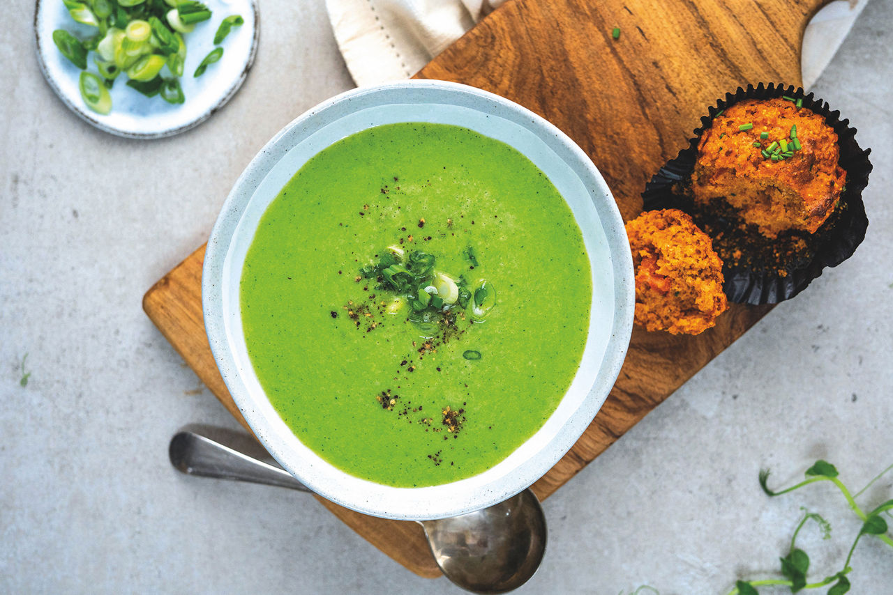 Sopa de guisantes en el bol con muffins